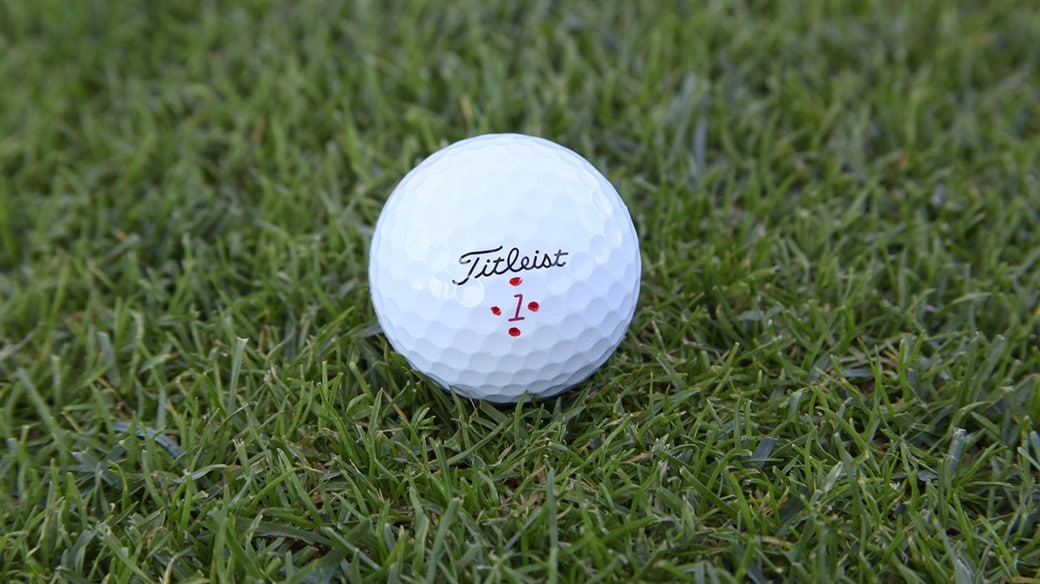 Justin Thomas's Pro V1x golf ball, marked with four Alabama Crimson dots around the play number